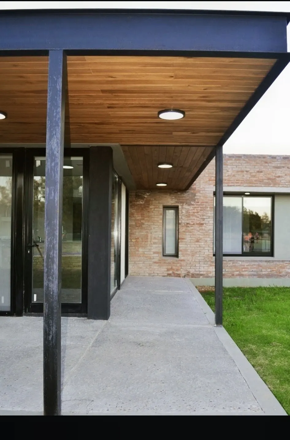 Pérgola metálica para patio moderno con estructura negra y acabado decorativo